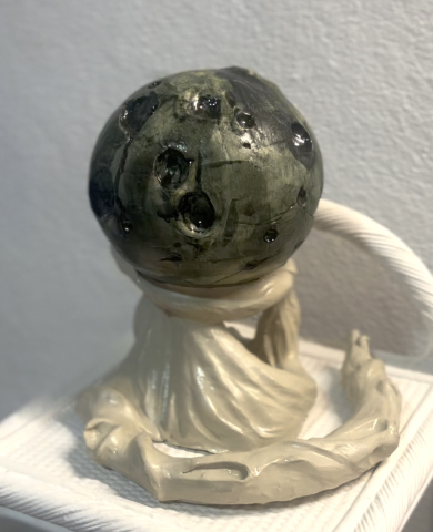 Sculpture en terre cuite, avec émaillage blanc et noir, représentation d'une lune sur un drapé de nuages veloutés